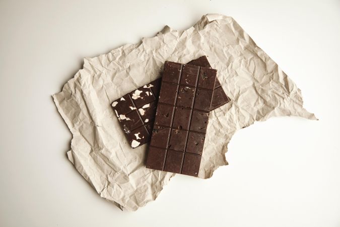 Two chocolate bars on paper and table