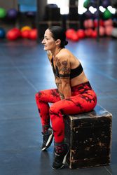 Female athlete resting sitting on a box in a gym