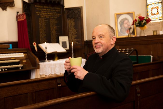 Vicar with tea in church