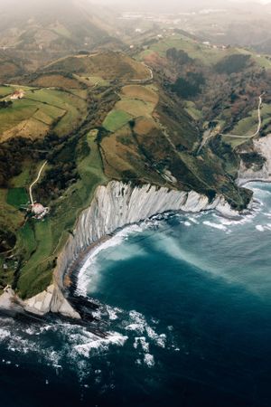 Sea waving near green hills
