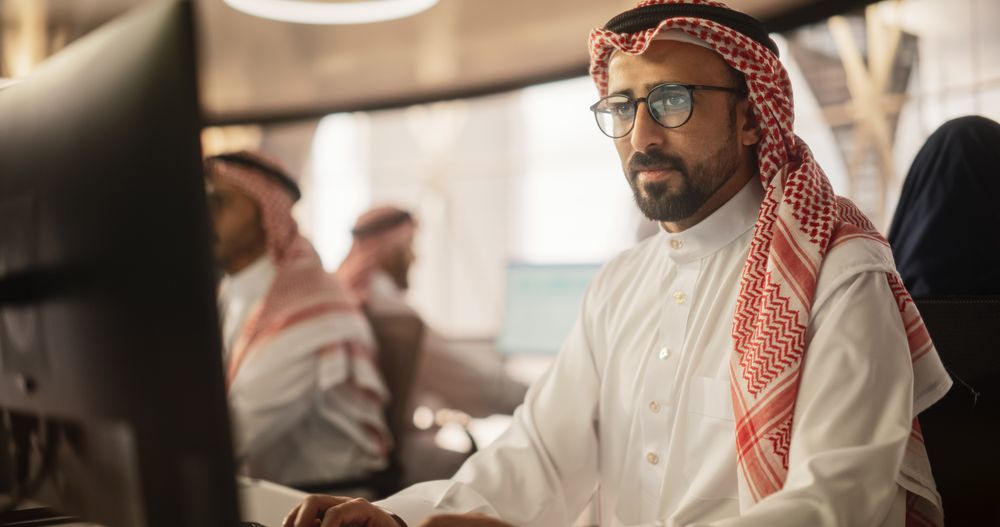 Portrait of a Smart Focused Middle Eastern Programmer Working on Computer in a Technological Corporate Office.