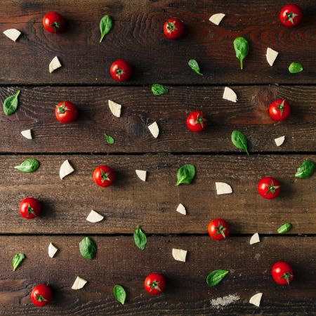 Basil, tomatoes, and cheese on wooden background