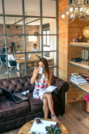 Businesswoman drinking coffee and working in a coworking office