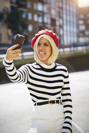 female in red beret taking selfie