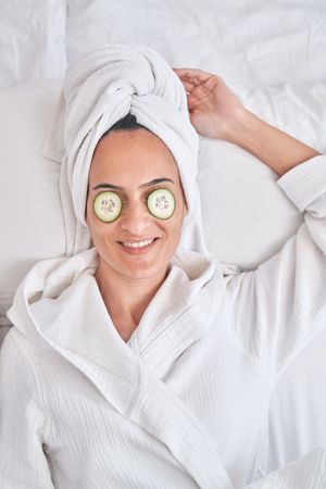 Woman with cucumber slices on eyes