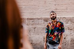 Faceless female taking photo of bearded man