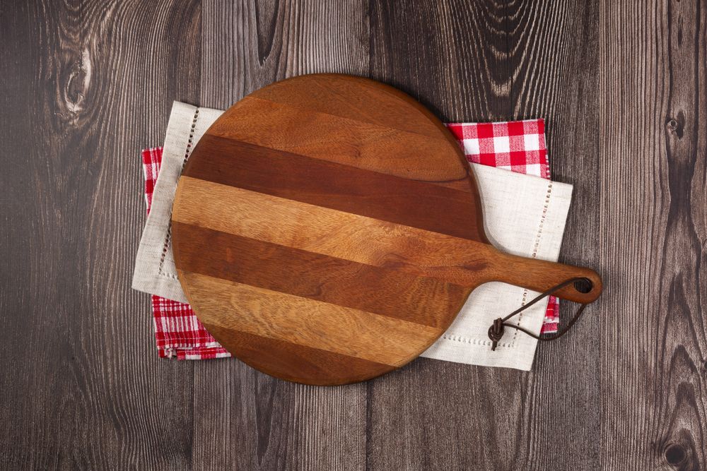 Empty pizza board on rustic wooden table. Top view image.