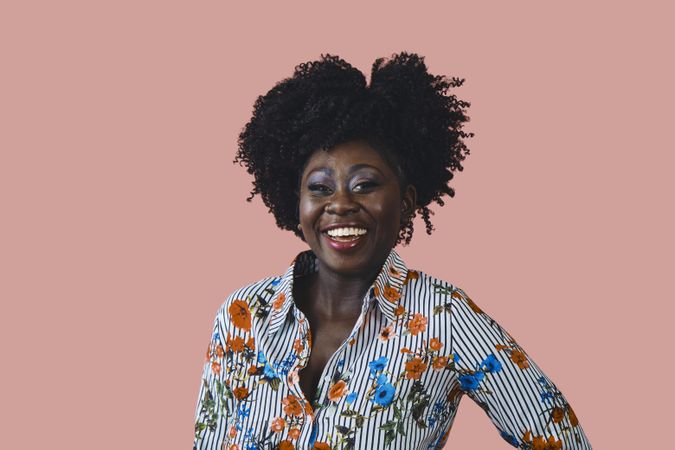 Studio shot of joyful Black woman in floral print shirt