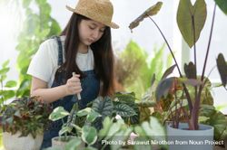 Asian female working in a green house with a gardening fork 5k3Mo5