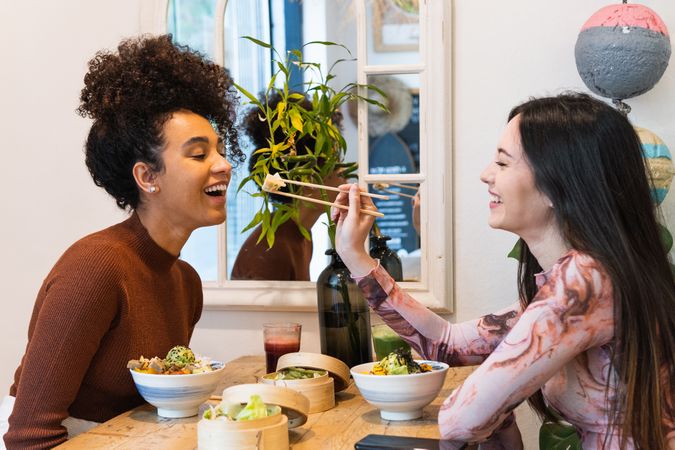 Friendly diverse women eating in restaurant together