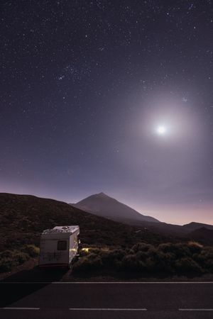 Traveling caravan in desert with bright moon