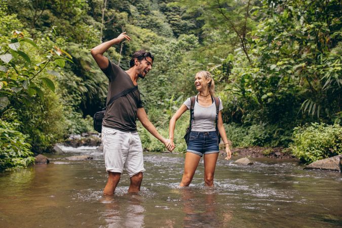 Excited young couple in mountain stream