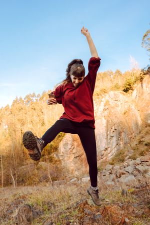 Young woman with smartphone dancing