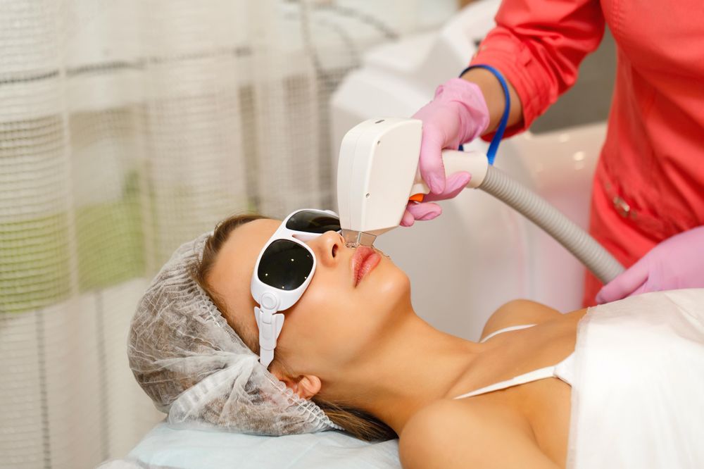 Female face with laser hair removal tool on cheek
