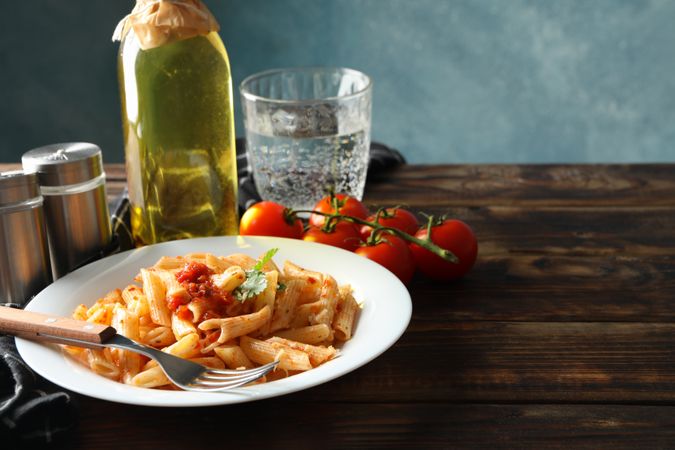 Composition with plate of tasty pasta on wooden background. Cooking pasta
