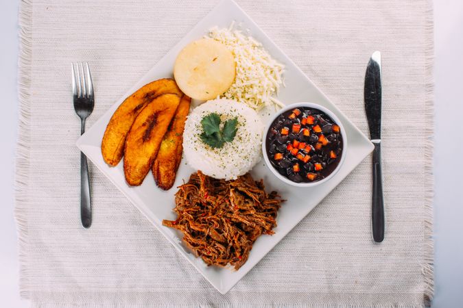 Homemade Venezuelan food. Traditional Venezuelan dish. Pabellon Criollo. White Rice, beans, Fried plantains, and Shredded beef
