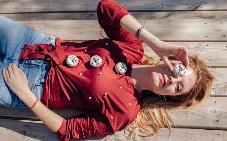 Woman looking through donuts hole on picnic