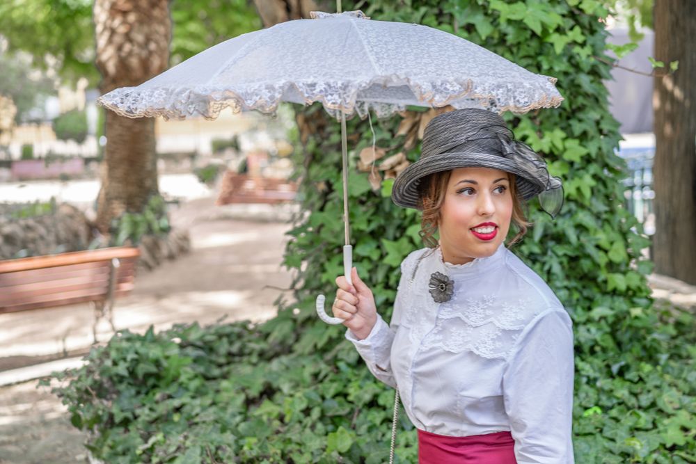 Vintage woman with parasol resting in garden