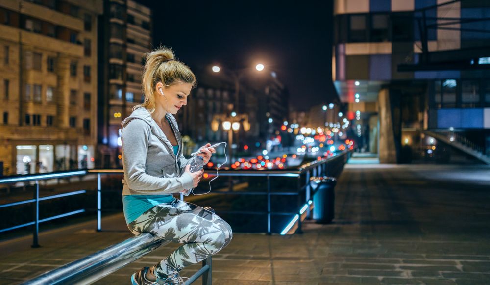 Smiling woman looking her messages on mobile app after training