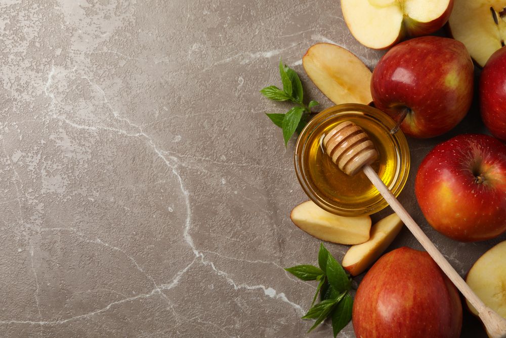 Top view of apples and honey on marble with copy space