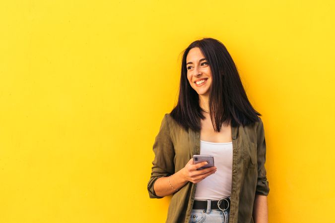 young stylish woman using her mobile and looking aside