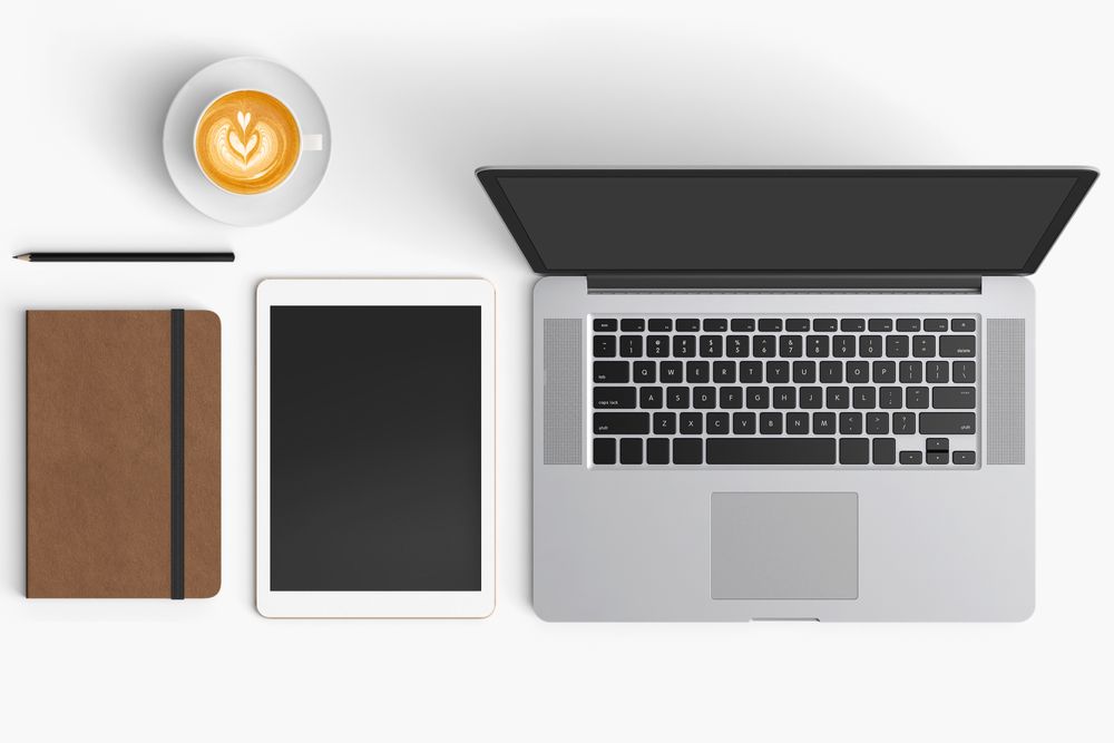 Modern workspace with coffee cup, smartphone, paper, notebook, tablet and laptop copy space