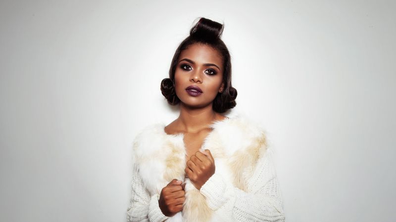 Studio photography of woman wearing makeup and light fur jacket