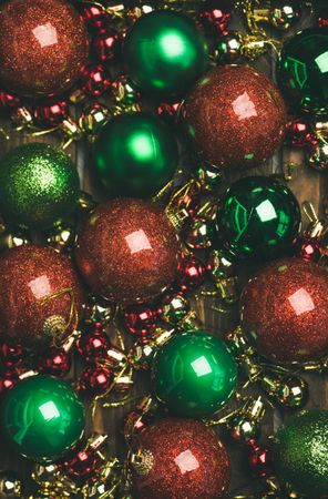 Close up of tree ornaments, large and small red, green and gold baubles, vertical composotion