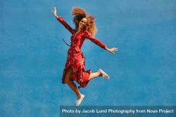 Young female model in red sundress jumping with joy 0VqKkb