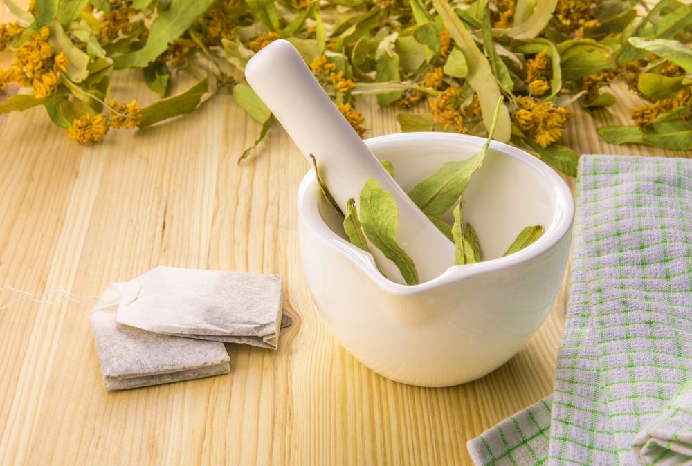 Linden flowers in a mortar and tea bags