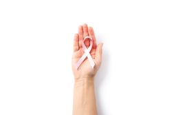 Female hand hold pink awareness ribbon, isolated on blank background
