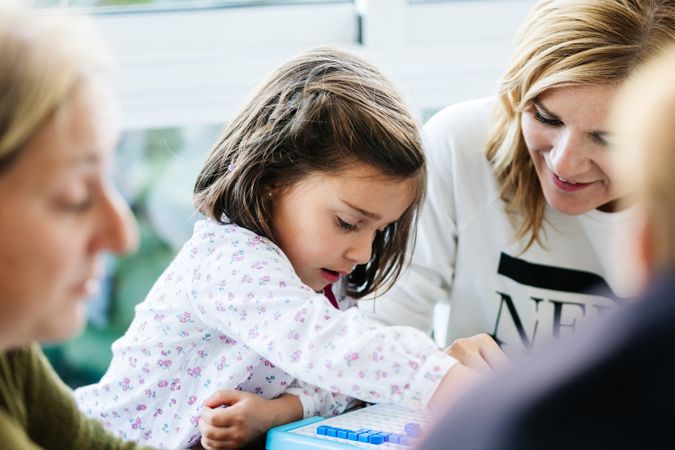 Woman playing board game with daughter and granddaughter