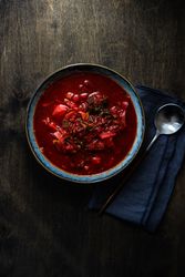 Top view of Ukrainian beetroot soup borscht in blue bowl