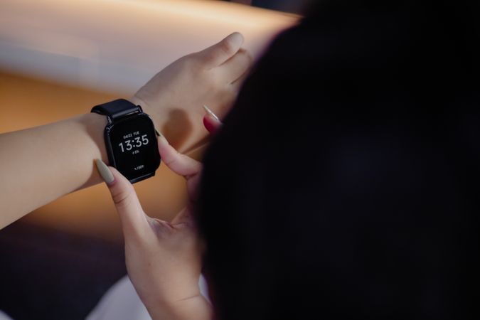 Stylish woman using a modern smartwatch for communication and tr