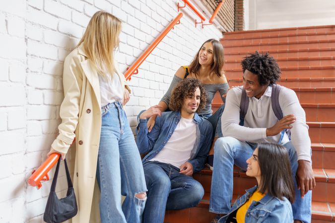 Happy friends talking with each other on brick steps