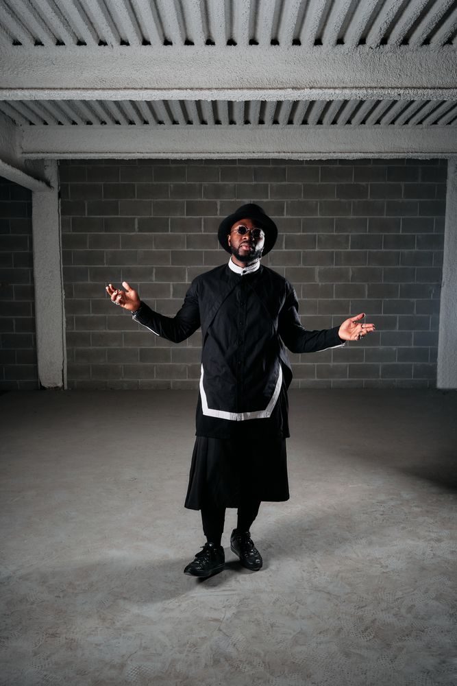 Man wearing dark clothes standing in studio