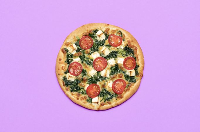Pizza vegetarian top view isolated on a purple background