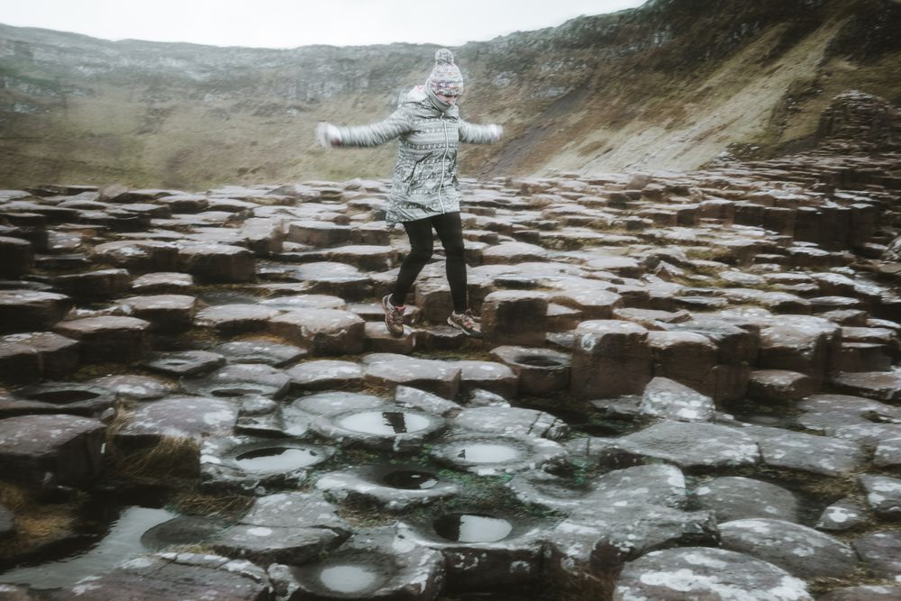 Female standing on cliff and contemplating