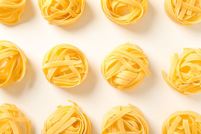 Flat lay composition with different pasta on light background, space for text and closeup