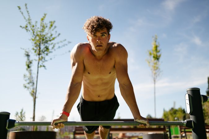 Strong young sportsman doing calisthenics