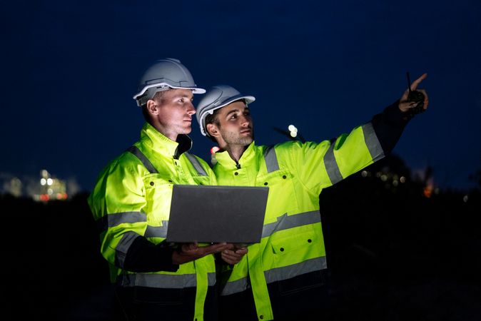 Engineer worker watching work monitor on digital tablet and talking to colleague