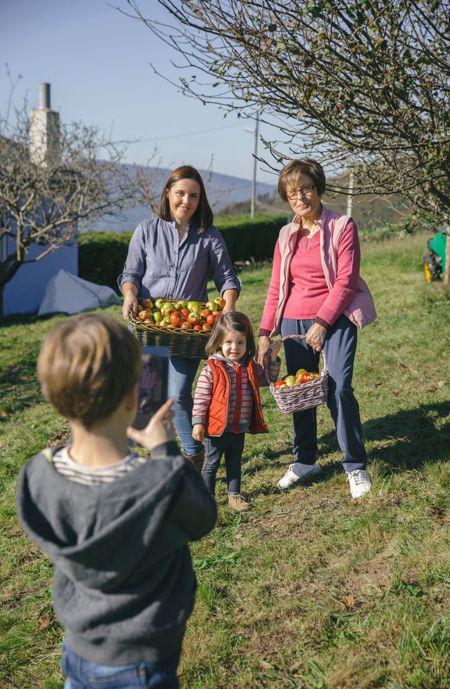 Young family with apples in basket posing for photo