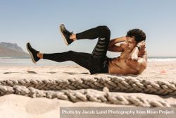 Side view of fit man doing abdomen workout on a beach 5rleMb