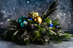 Side view of Christmas festive centerpiece with candle and pine arrangement