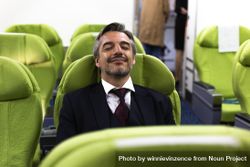 Content man with eyes closed in empty airplane cabin 4AdDN5