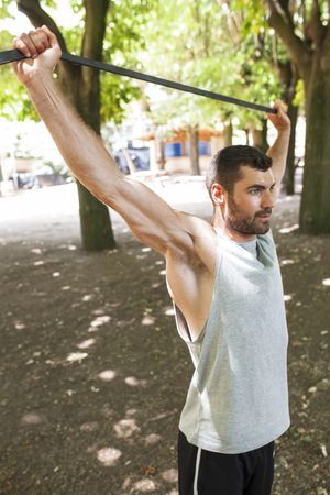 Sportsman stretching arms in park