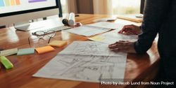 Close up of woman designer with house plan working at her desk bx39B4