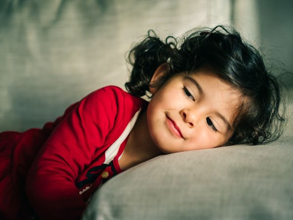 Cute dreamy girl lying down on pillow