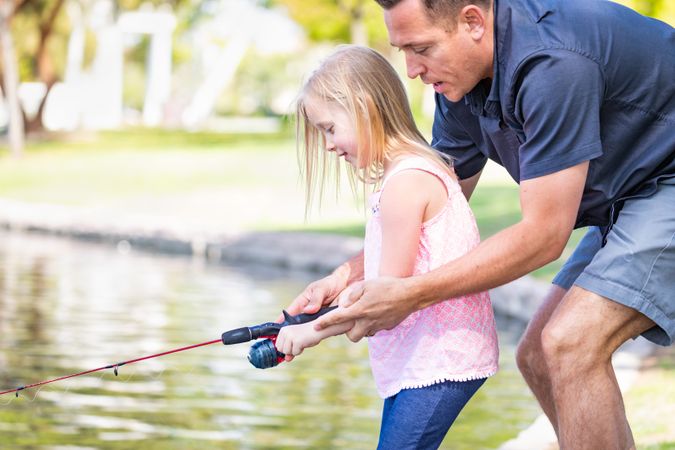 Father and Daughter Having Fun Fishing At The Lake