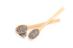 Chia seeds and wooden spoons isolated on plain background